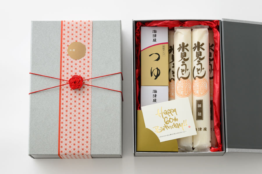 グレーの箱に入ったうどんとつゆの還暦祝いセットラッピング