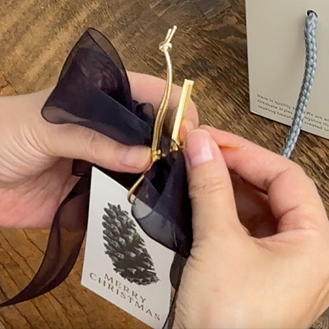 ［7］タグのゴムを一緒に持ち､ワイヤータイで挟み､ねじって留めます｡