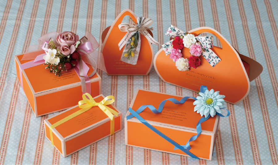 春夏には明るいカラーの造花やリボン、ワイヤータイを組み合わせて爽やかな印象に。