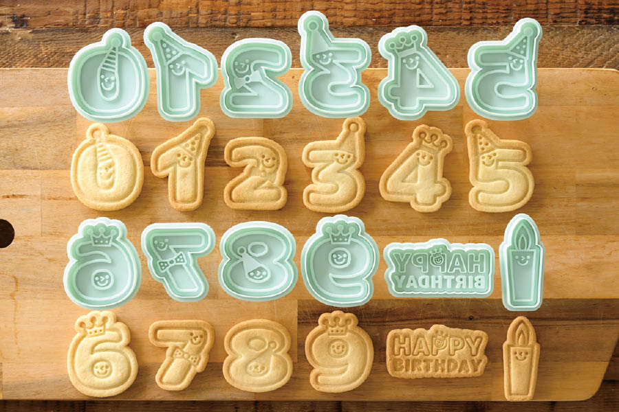 数字などのスタンプ式クッキー型と焼き上げたクッキーを並べているところ