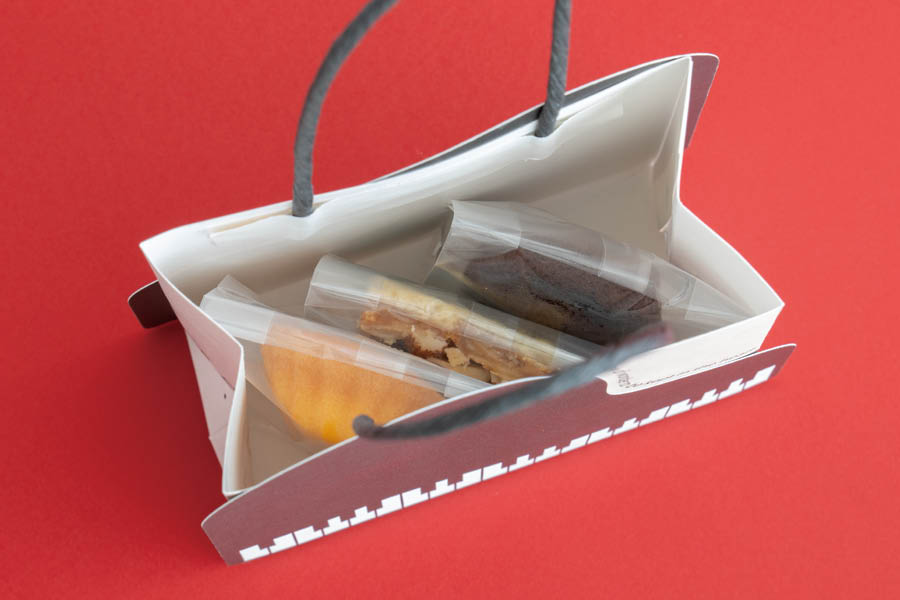 ピアノデザインのペーパーバッグに焼菓子を3個いれたところ
